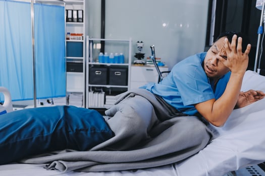 A man laying on a hospital bed with his head on the pillow photo
