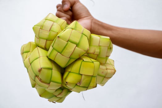 Close-up of hand holding traditional Ketupat food for Eid celebrations photo