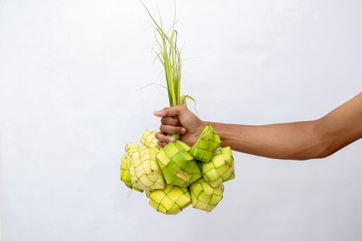 Hand holding delicious ketupat, traditional Indonesian rice dumpling delicacy photo