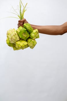 Hand Holding Ketupat, Traditional Rice Cake for Eid Celebration Moment photo