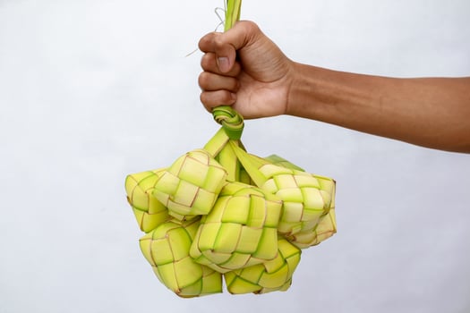 Hand holding ketupat, a rice dumpling popular during Eid al-Fitr celebration photo