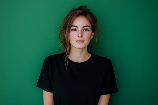 A woman in a black t - shirt posing against a green wall photo
