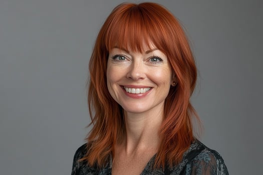 A woman with red hair smiling for the camera photo