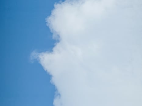 A vivid blue sky with soft, fluffy white clouds, ideal for relaxation, travel, abstract backgrounds, and nature-themed designs. Gently blurred for a dreamy effect photo