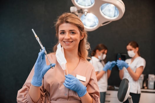 Four women.. Doctor holding syringe. In the stomatological cabinet photo