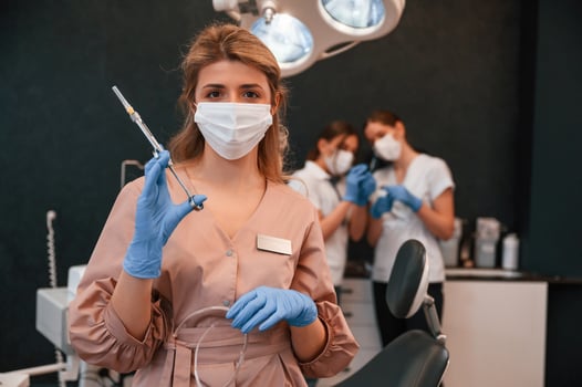 Four women. Doctor holding syringe. In the stomatological cabinet photo