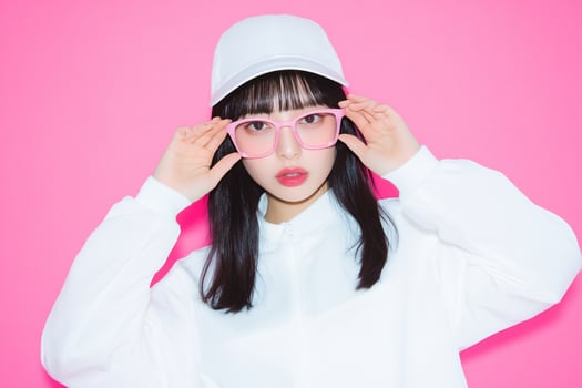 A woman wearing a white shirt and pink glasses photo