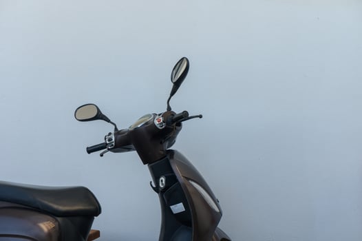 Motorcycle parked against a minimalistic white wall, showcasing urban lifestyle and mobility culture in vibrant city setting photo