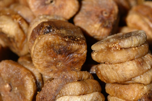 Dried figs piled together showcasing rich textures and natural sweetness in a lively market setting photo