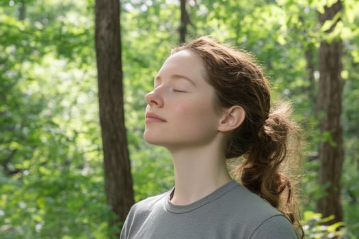 A woman in a gray shirt is looking up at the sky photo