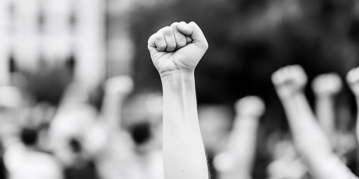 Black and white image of a person holding up their fist photo