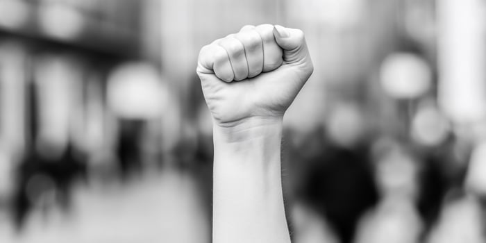 A black and white photo of a fist raised in the air