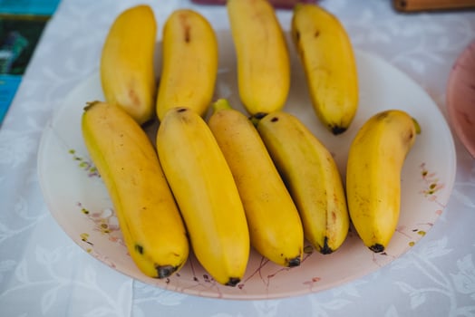A beautiful, vibrant plate brimming with fresh, ripe, and delicious bananas rests elegantly on a nicely arranged table, eagerly waiting to be savored and enjoyed by everyone who is present photo