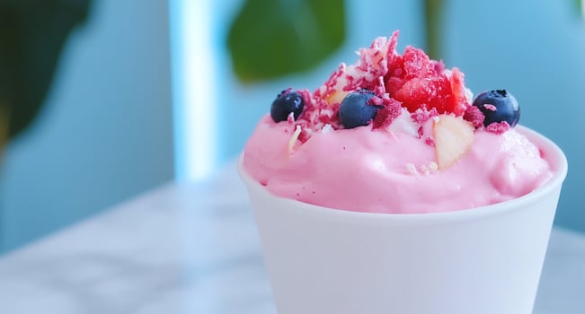 A delicious pink dessert topped with fruits and coconut flakes. photo