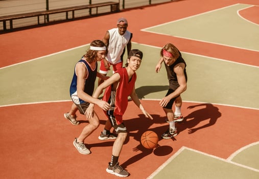 Team of professional basketball players fighting for ball on outdoor arena photo