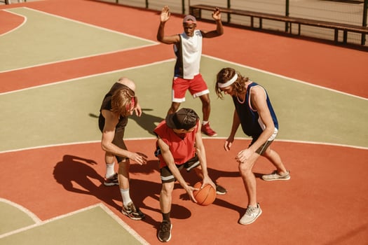 Professional multiethnic sportsmen playing basketball game at outdoor playground photo