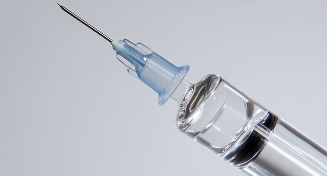 Close-up of a syringe needle with liquid, used for injections. photo