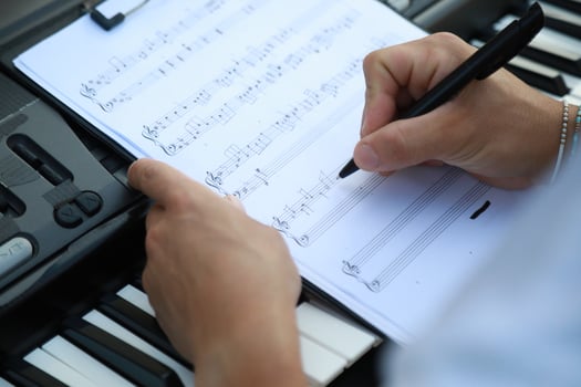 Man Writes Chords On Sheet Music And Study On Keyboard Instrument Outdoor photo