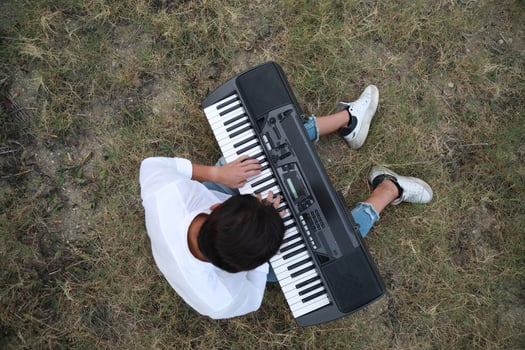 Musician Boy Plays The Keyboard Sitting In The Meadow In Calabria Countryside Outdoor photo