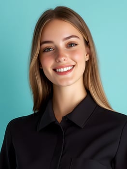 Portrait of a young smiling woman dressed in a black business jacket against a teal blue background conveying a friendly and professional demeanor photo