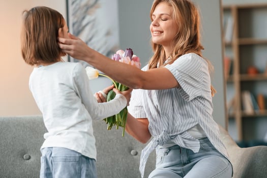 Happy ,mother's day, giving ,flowers. Woman with her little daughter is together in domestic room photo
