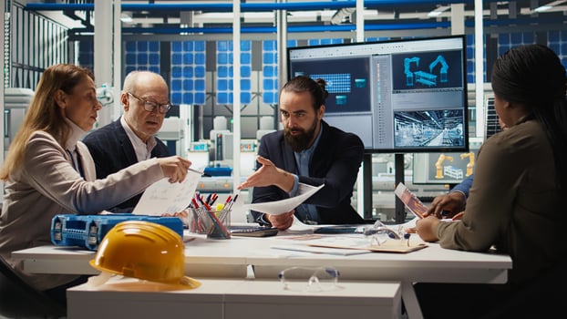 Engineers study detailed schematics of solar panel assembly lines, refining layouts and component configurations for efficiency. Researchers outlining documentation for new prototypes, camera A photo