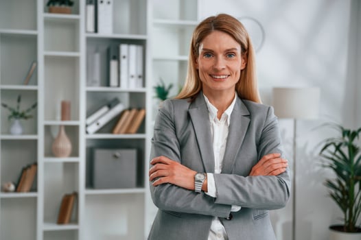 Standing with, arms crossed. Woman in business formal clothes is working in office photo