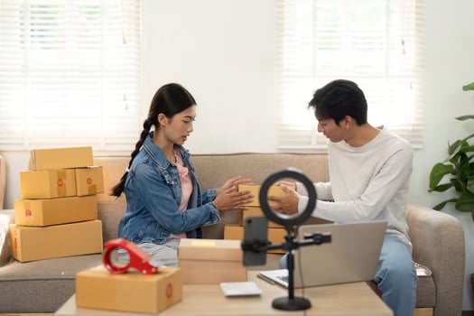 Packaging and Creativity. A couple organizing their products for an online business while sharing ideas. photo