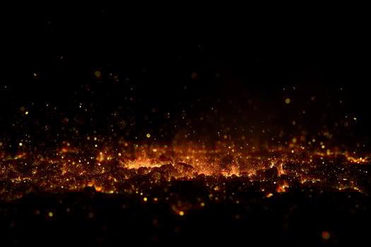 A pile of burning coal with embers and smoke against a black background, creating a dramatic and intense visual effect photo