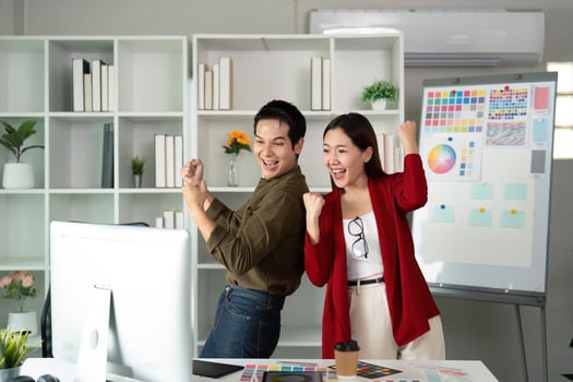 Celebration and Accomplishment. Two designers celebrate a successful collaboration in a vibrant design studio. photo