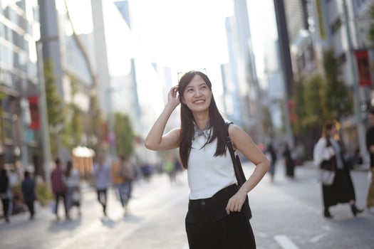 Embrace the urban vibe as a young Asian woman showcases a blend of style, confidence, and a carefree spirit on her city stroll. photo