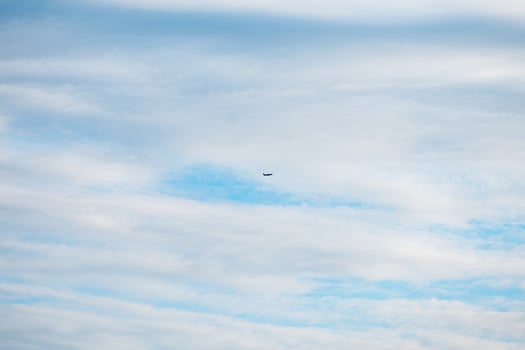 Small airplane soaring high in a partly cloudy sky, leaving a white contrail behind on a stunning summer day filled with sunshine and adventure in the atmosphere photo