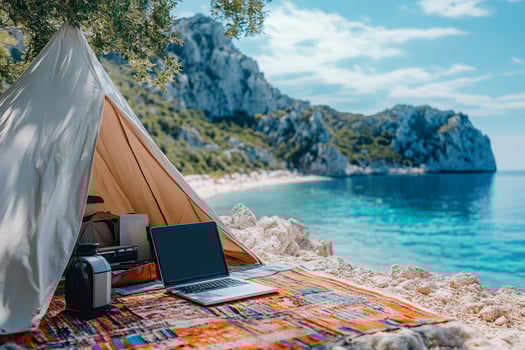 Freelancer working remotely from tent near tropical beach with laptop photo