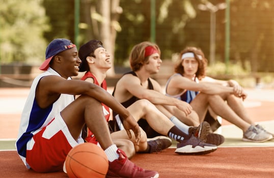 Team of professional basketballers communicating after tournament at outdoor arena, free space photo