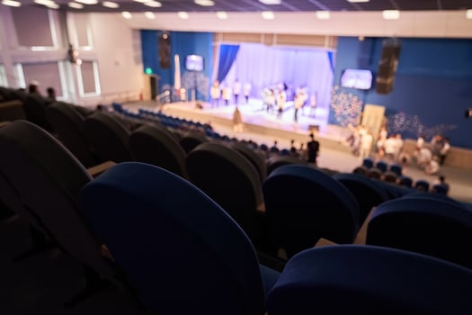 The rehearsal of the play. People in the auditorium are watching the performance. A music concert or festival. Out of focus. photo