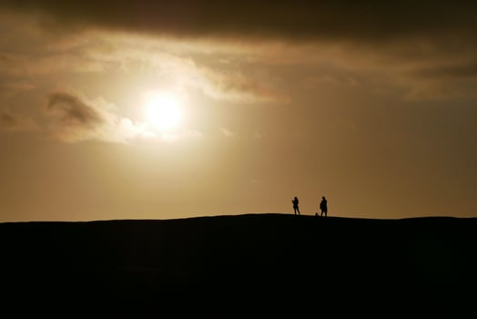 People watching a colorful sunset in a Maspalomas dune, Gran Canaria island photo