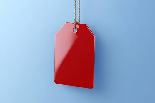 A shiny red price tag hanging against a blue background. photo