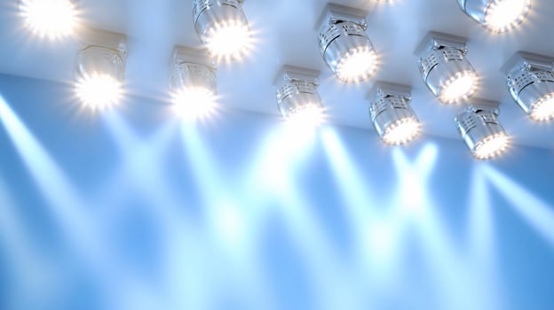 Bright stage lights illuminating a blue background for performance. photo