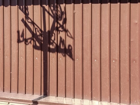 Texture of modern metallic brown fence with weathervane shadow outline photo
