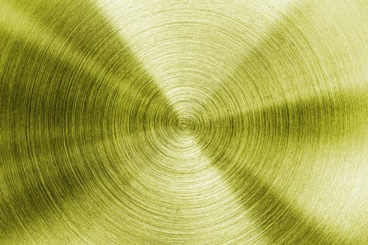 A gold metal plate with a circular pattern photo