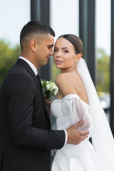 Groom embracing bride during wedding day photo