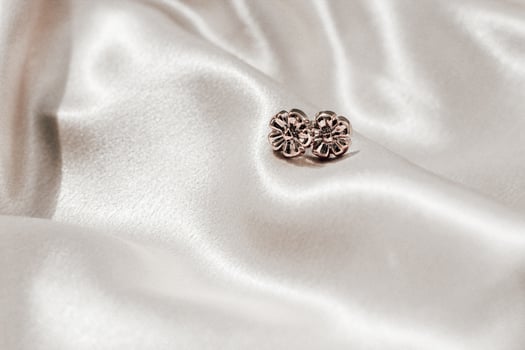 Gold earrings decoration on golden silk fabric with space for text photo