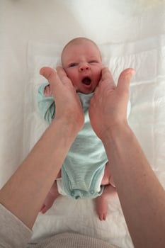 Adorable caucasian newborn baby and his mother hands. photo