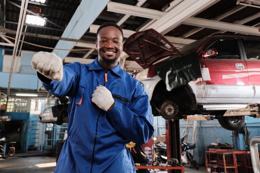 Cheerful Black male mechanic, cheerful works and pose with smile in fix car garage, professional engineer maintenance jobs in automotive and transportation industry business. photo