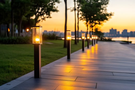 Glowing street lamps illuminating park walkway at sunset photo