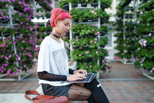 Gen z girl leather fashion with punk Asian woman working remotely on laptop digital nomad in Thailand. photo
