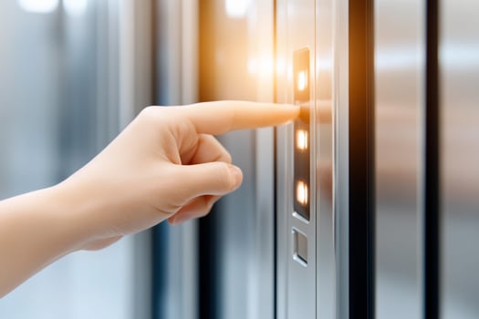 A person pressing a button on a metal elevator door photo