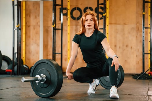 Front ,view. Sitting, barbell, on the floor. Beautiful strong woman is in the gym photo