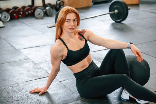 Sitting on the floor. Beautiful strong ,woman is in the gym photo