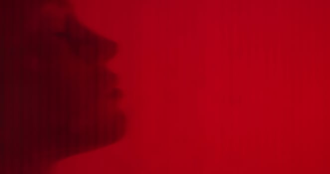 A woman in the shower. Close-up of her face in profile. The view from behind the glass photo